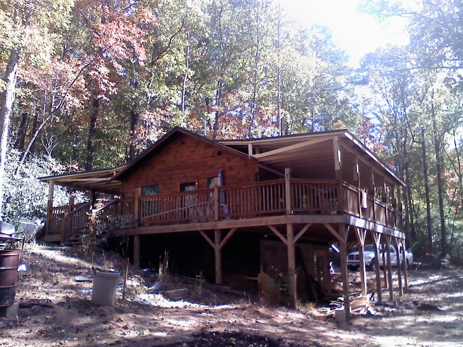Log cabin with a wraparound porch and metal roof in the fall in Jackson